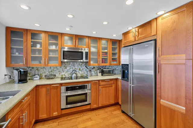 a kitchen with stainless steel appliances granite countertop a refrigerator and a sink