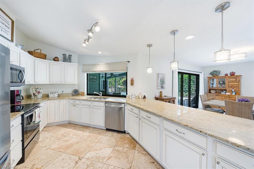 a large kitchen with kitchen island granite countertop lots of counter space and a sink