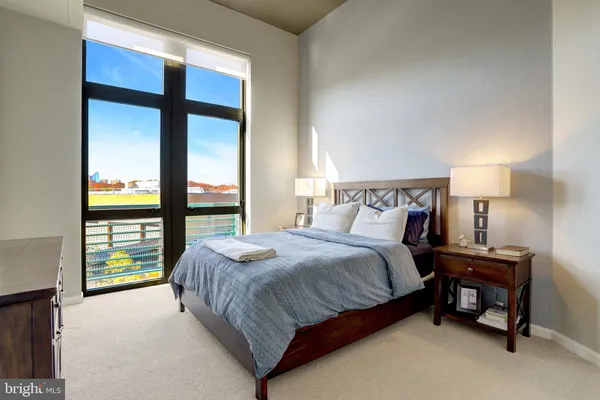 a bedroom with a bed and a lamp next to a window