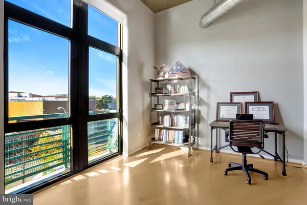 a view of a workspace with furniture and a window
