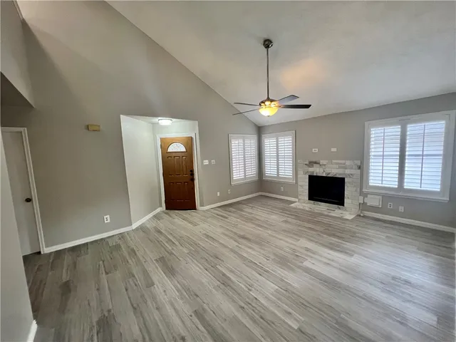 a view of an empty room with window and wooden floor