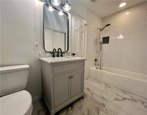 a bathroom with a sink toilet vanity and shower