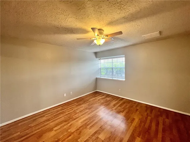 an empty room with a window and a ceiling fan
