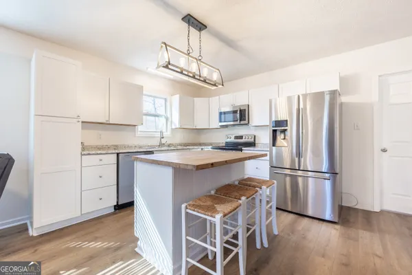 a kitchen with cabinets stainless steel appliances a sink and a window