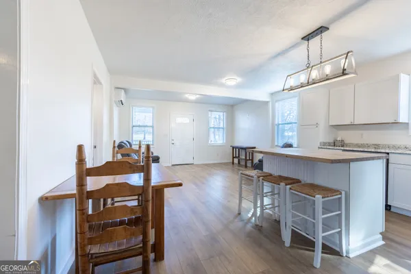 a kitchen with a table chairs refrigerator and cabinets