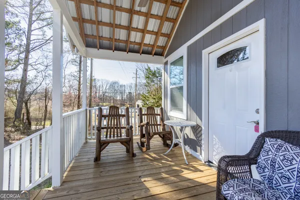 a view of a porch with furniture and wooden floor