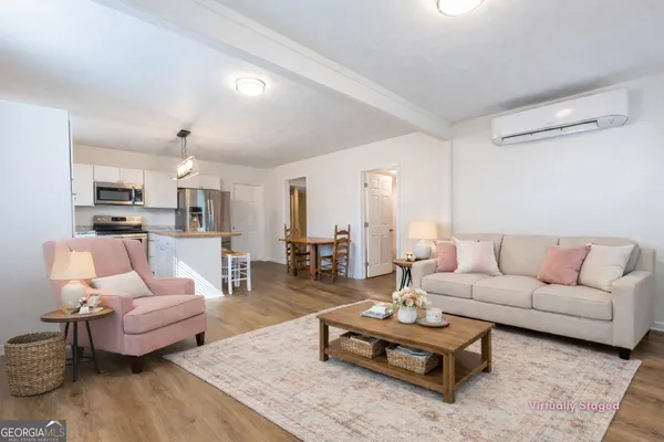 a living room with furniture wooden floor and a view of kitchen