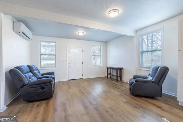 a living room with furniture and a wooden floor