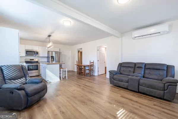 a living room with furniture and kitchen view