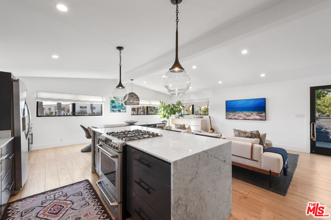 29500 Heathercliff Road, Unit 14 Malibu, CA 90265 - Photo 11 of 28 a open kitchen with stainless steel appliances granite countertop a stove and a wooden floor