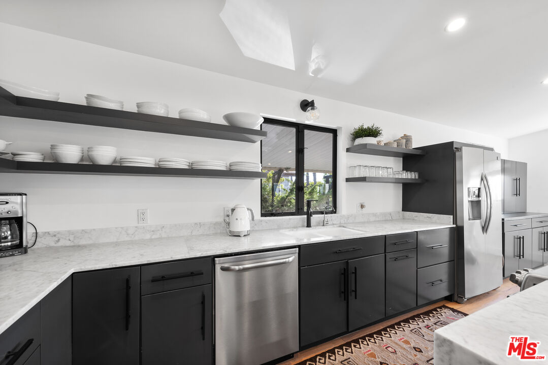 29500 Heathercliff Road, Unit 14 Malibu, CA 90265 - Photo 10 of 28 a kitchen with stainless steel appliances a sink and cabinets
