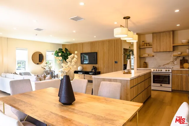 a kitchen with a stove a sink a microwave a dining table and chairs