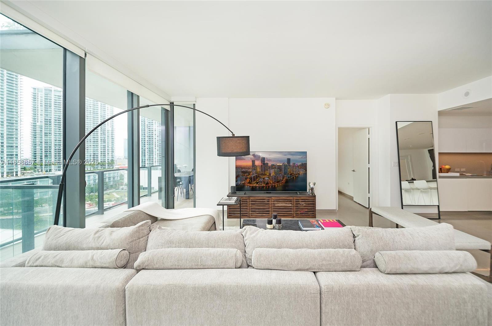 68 Southeast 6th Street, Unit 1008 Miami, FL 33131 - Photo 11 of 37 a living room with furniture and a flat screen tv