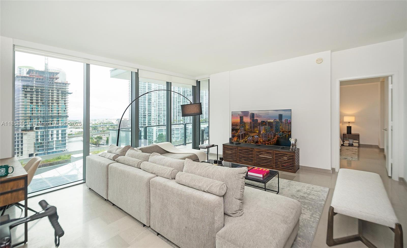 68 Southeast 6th Street, Unit 1008 Miami, FL 33131 - Photo 12 of 37 a living room with furniture and a flat screen tv