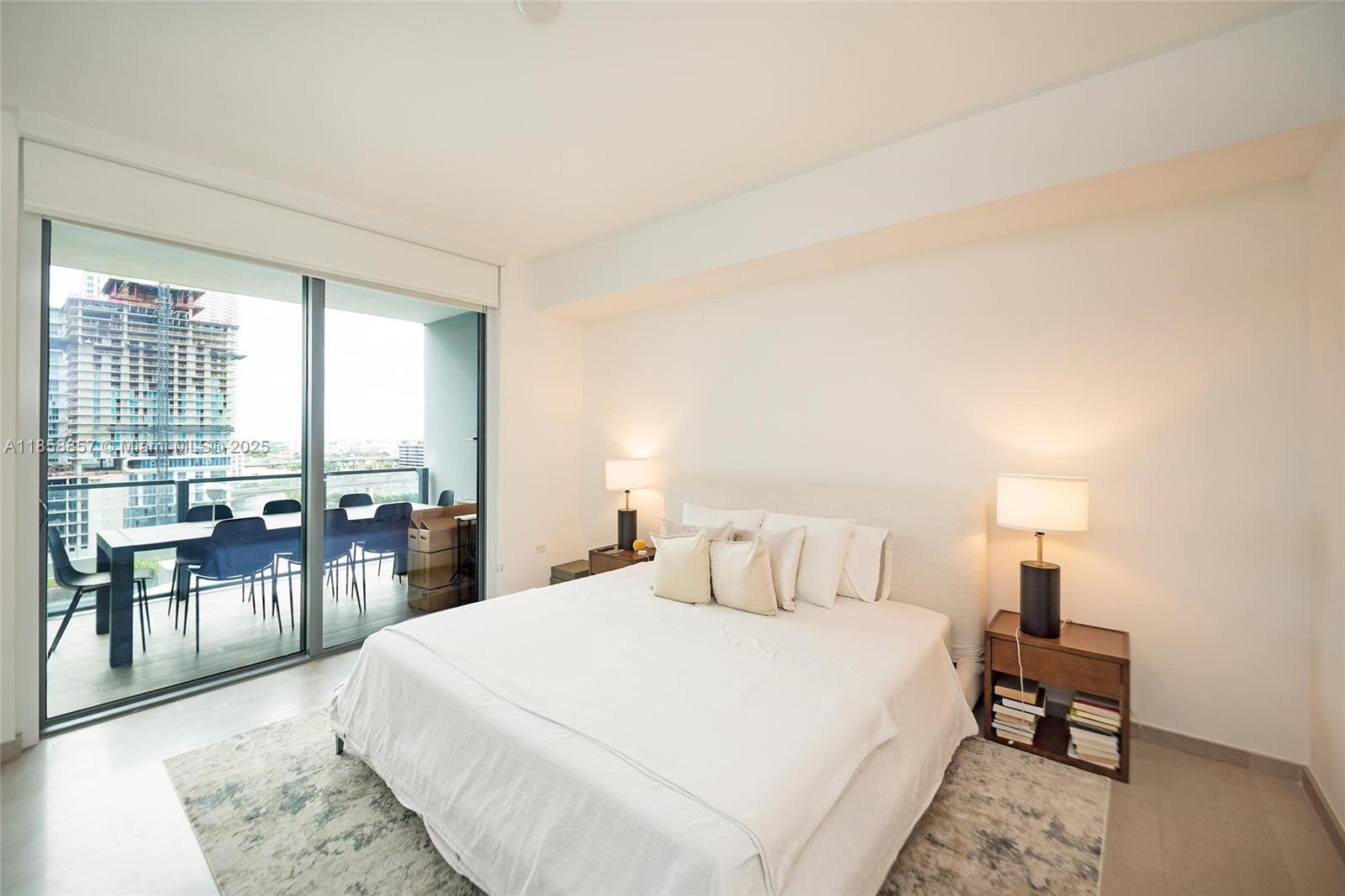 68 Southeast 6th Street, Unit 1008 Miami, FL 33131 - Photo 14 of 37 a bedroom with a bed a large window with table and chair