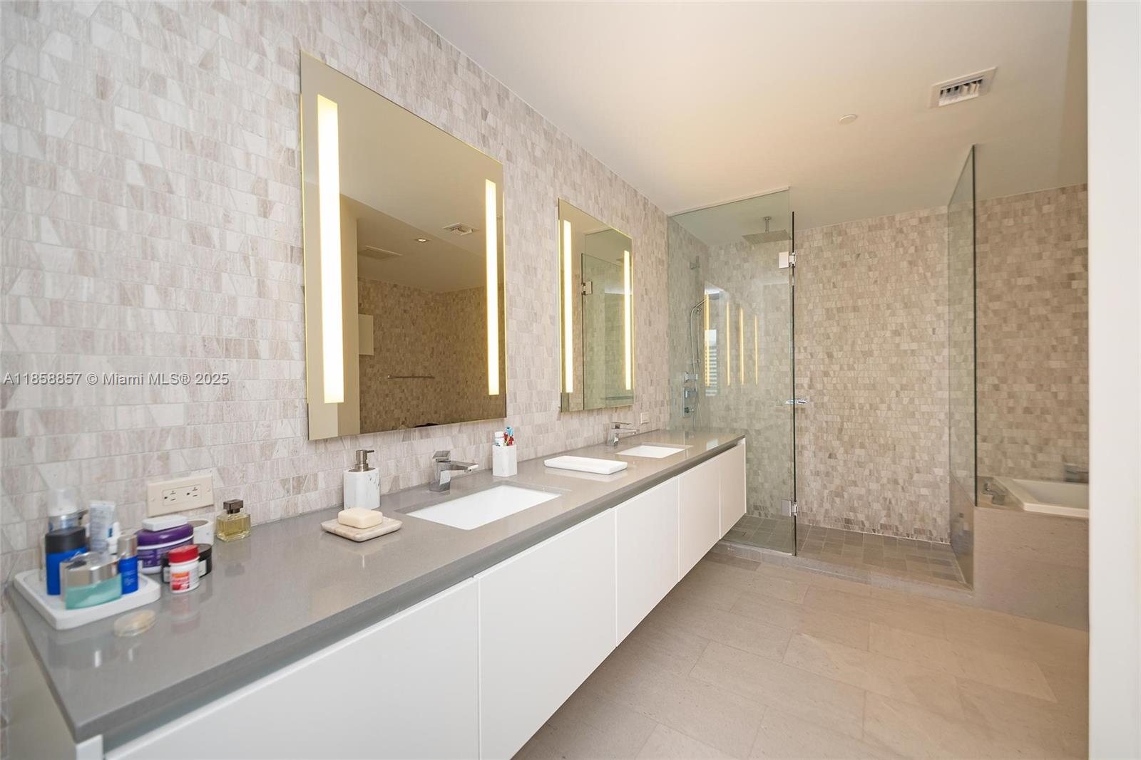 68 Southeast 6th Street, Unit 1008 Miami, FL 33131 - Photo 17 of 37 a bathroom with a double vanity sink mirror and shower