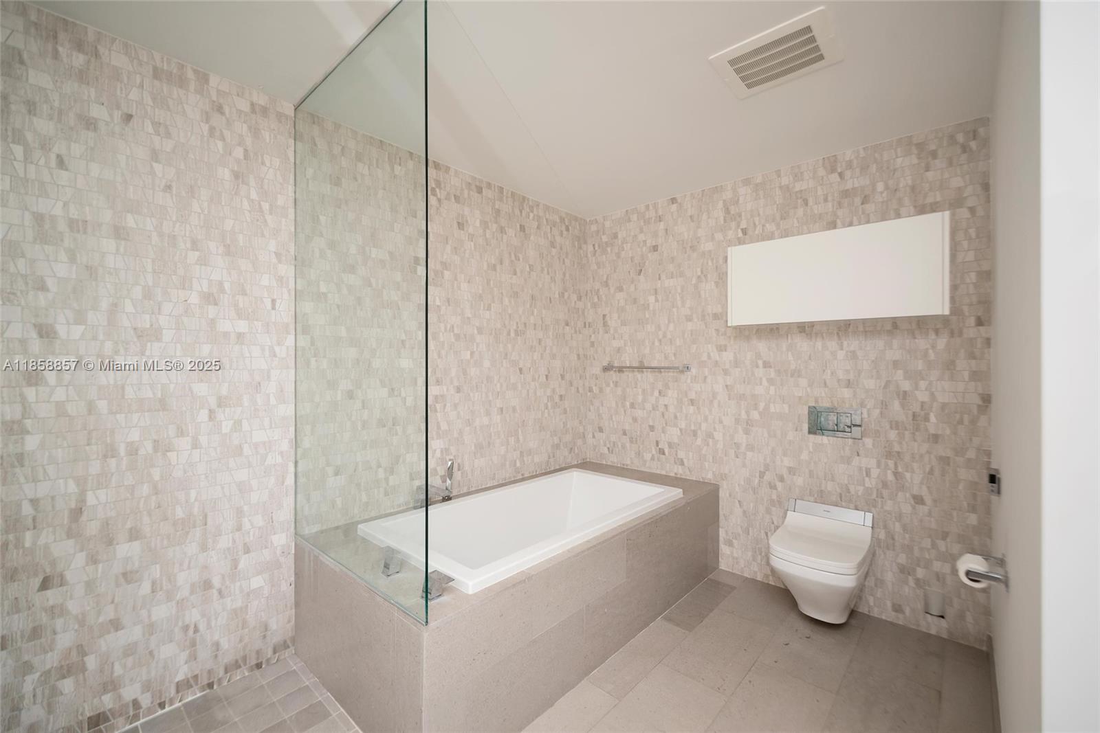 68 Southeast 6th Street, Unit 1008 Miami, FL 33131 - Photo 18 of 37 a bathroom with a bathtub and toilet