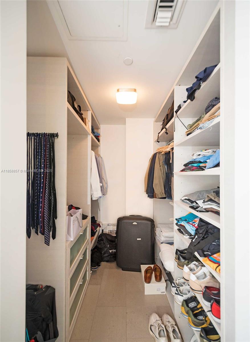 68 Southeast 6th Street, Unit 1008 Miami, FL 33131 - Photo 19 of 37 a view of walk in closet with clothes and shoes