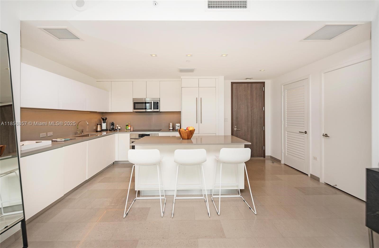 68 Southeast 6th Street, Unit 1008 Miami, FL 33131 - Photo 7 of 37 a kitchen with a sink and chairs