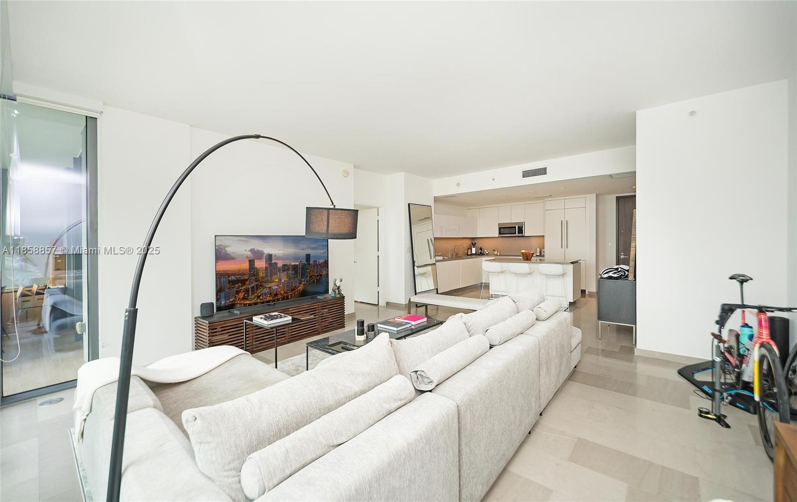 68 Southeast 6th Street, Unit 1008 Miami, FL 33131 - Photo 9 of 37 a living room with furniture and a flat screen tv