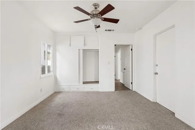 a view of an empty room with a ceiling fan