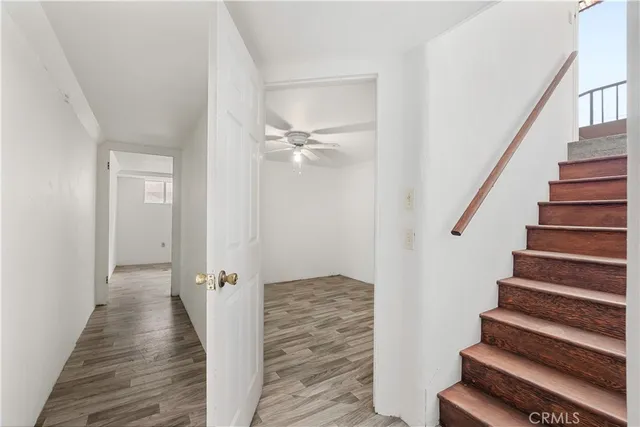 a view of a hallway with wooden floor and staircase