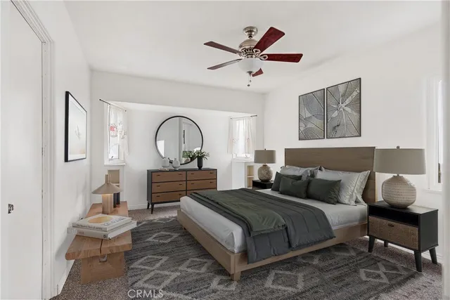 a bedroom with a bed a couch and a painting on the wall