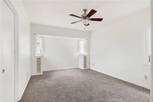 an empty room with closet and windows