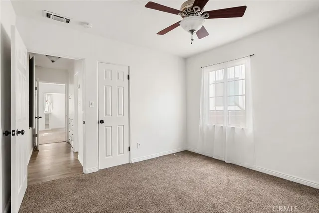 an empty room with fan and windows