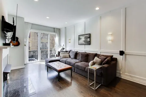 a living room with furniture a flat screen tv and a large window