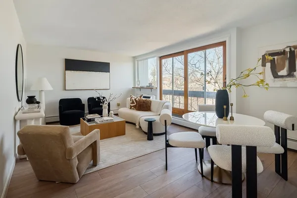 a living room with fireplace furniture and a large window