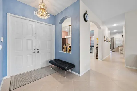 a view of a hallway with wooden floor and a chandelier