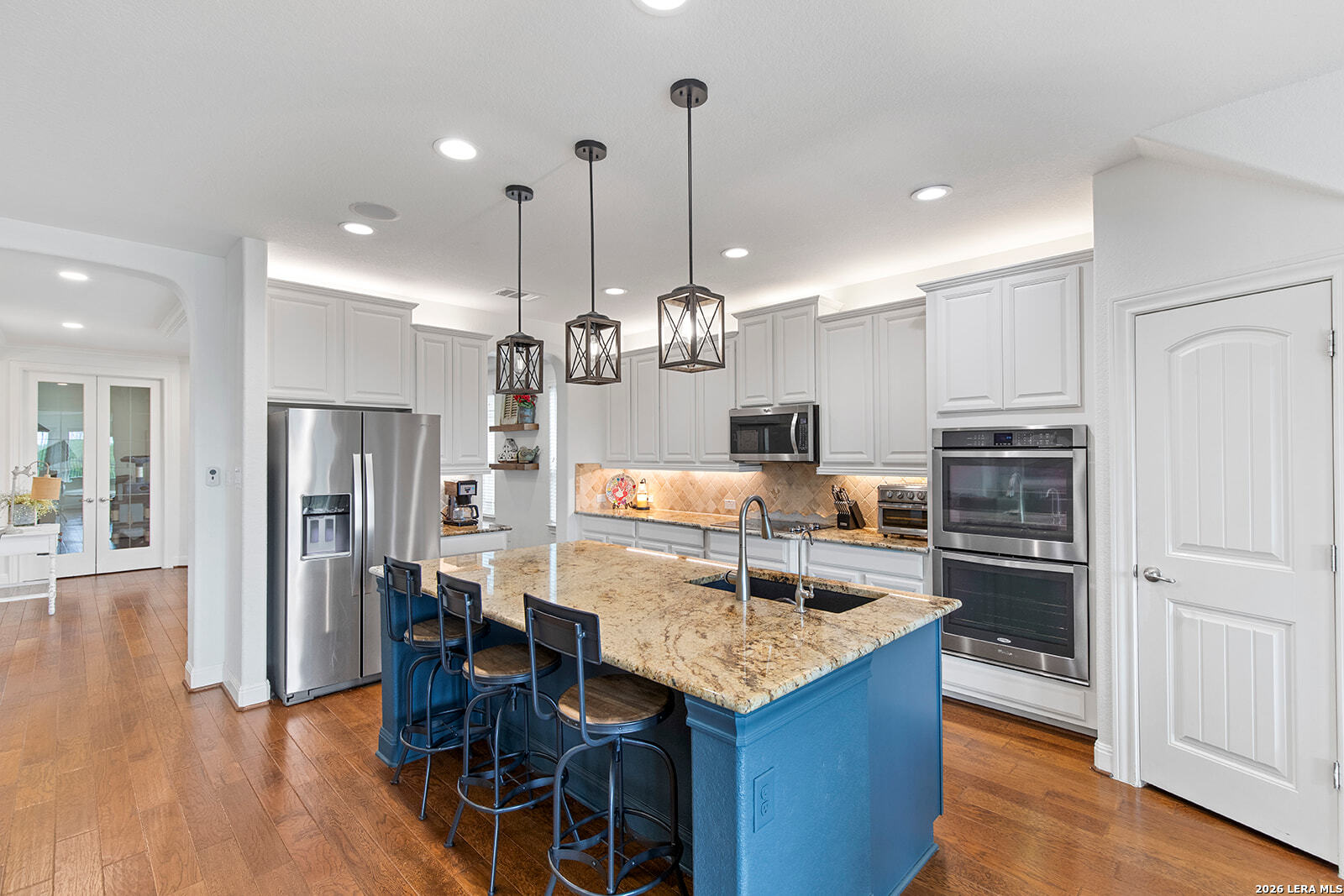 8039 Cibolo Valley Fair Oaks Ranch, TX 78015 - Photo 13 of 63 a kitchen with stainless steel appliances kitchen island granite countertop a refrigerator a oven a sink and a dining table with wooden floor