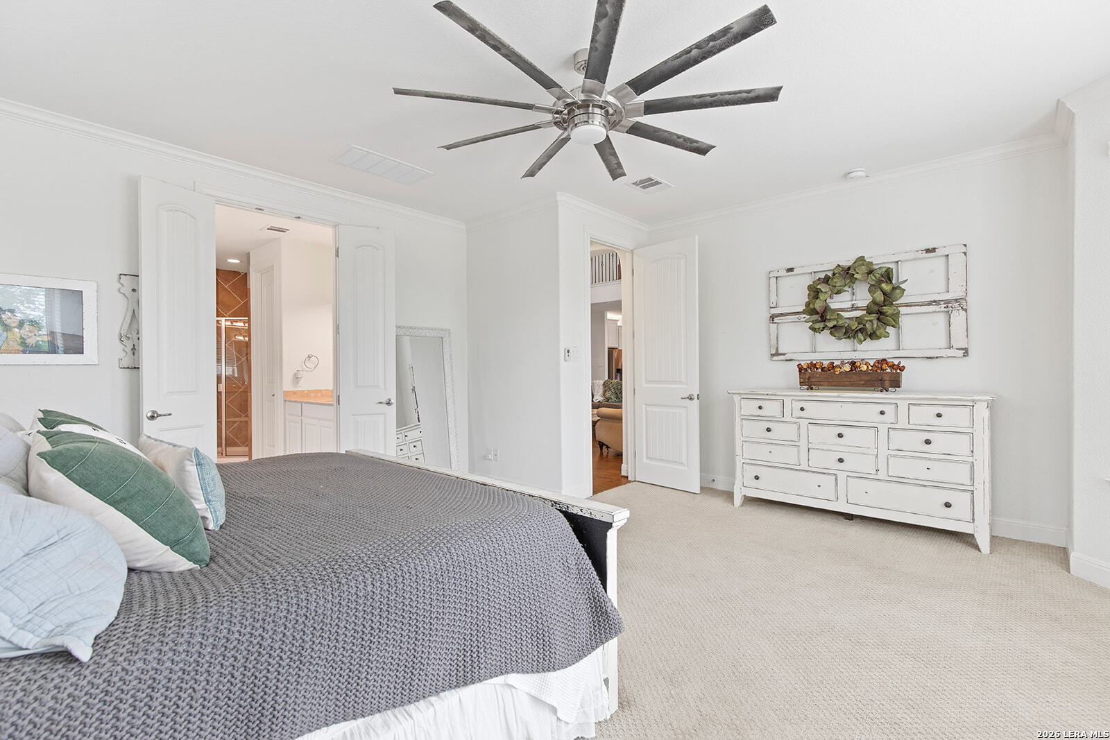 8039 Cibolo Valley Fair Oaks Ranch, TX 78015 - Photo 23 of 63 a bedroom with a bed a dresser and a chandelier