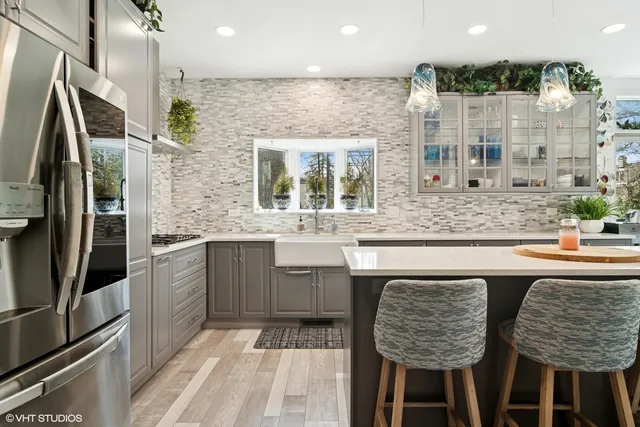 a kitchen with stainless steel appliances granite countertop a sink and a refrigerator