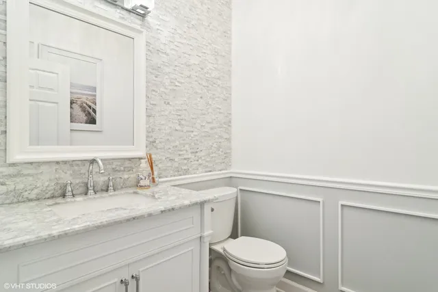 a bathroom with a granite countertop sink a toilet and a mirror