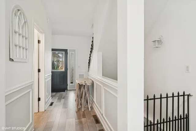 a view of a hallway with wooden floor and staircase