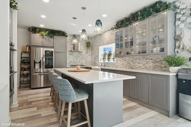 a kitchen with stainless steel appliances granite countertop a sink a stove and a refrigerator