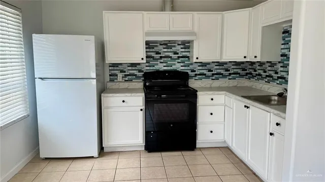 a kitchen with a refrigerator and cabinets