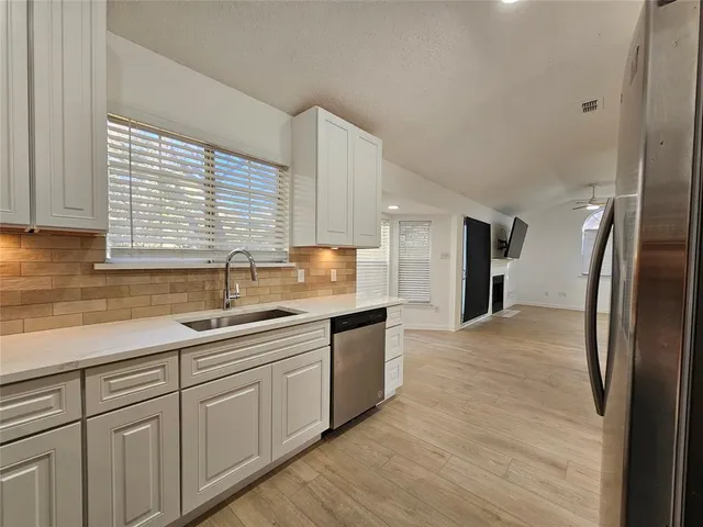 a large kitchen with kitchen island a sink stainless steel appliances and cabinets