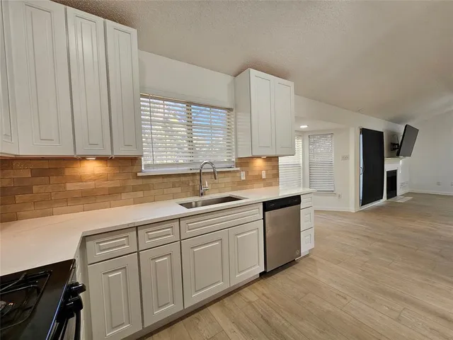 a kitchen with granite countertop white cabinets and white appliances