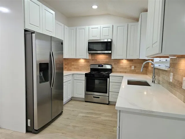 a kitchen with a sink a stove and refrigerator