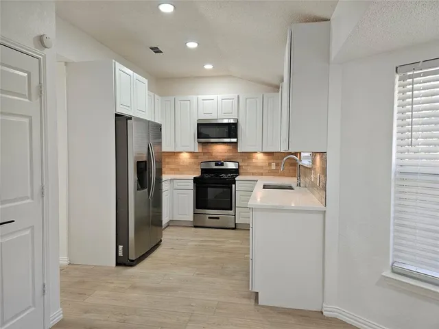 a kitchen with refrigerator and microwave