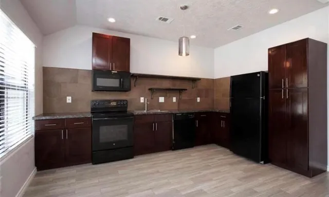 a kitchen with stainless steel appliances granite countertop refrigerator a stove a sink and dishwasher