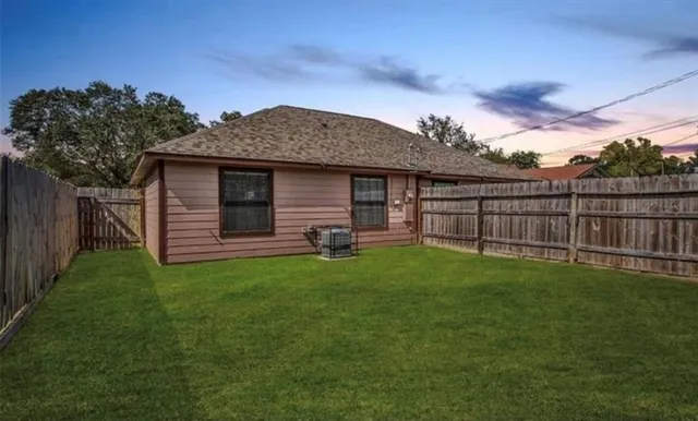 a view of a backyard with potted plants and large tree