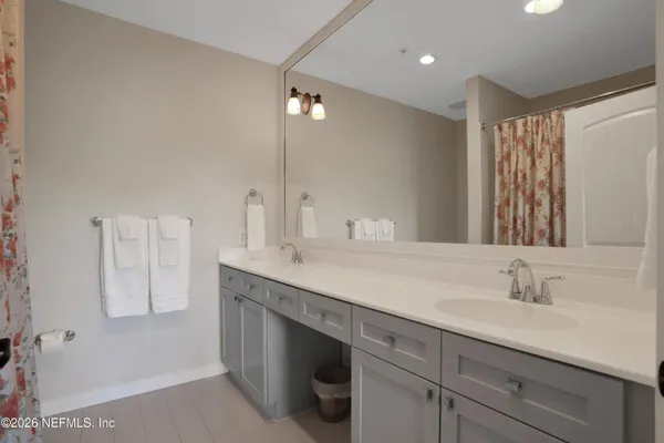 a bathroom with a double vanity sink a mirror and a shower