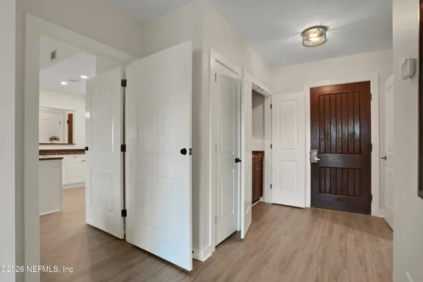 a view of a hallway with wooden floor and closet area