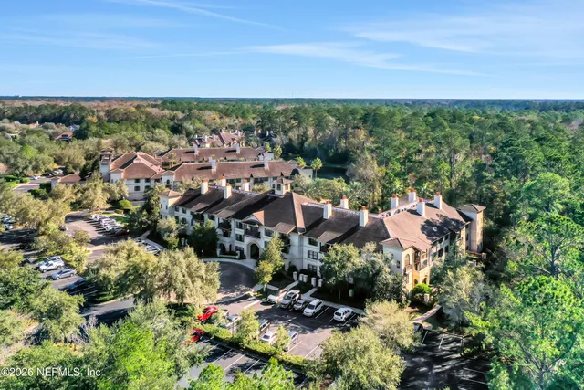 an aerial view of residential houses with outdoor space and ocean view