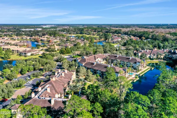 an aerial view of residential houses with outdoor space and trees