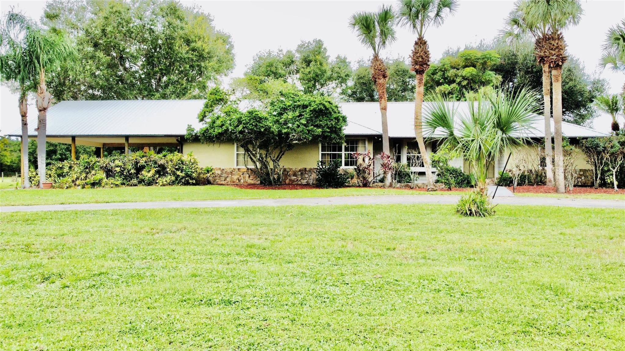395 Southwest 30th Terrace Okeechobee, FL 34974 - Photo 1 of 57 a front view of a house with garden